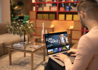 “Laptop connected to a TV screen showing media content, demonstrating how to connect my laptop to my TV using HDMI or wireless casting.”